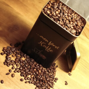 Kaffeburk i svartlackad metall med graverad text: ...men först kaffe.